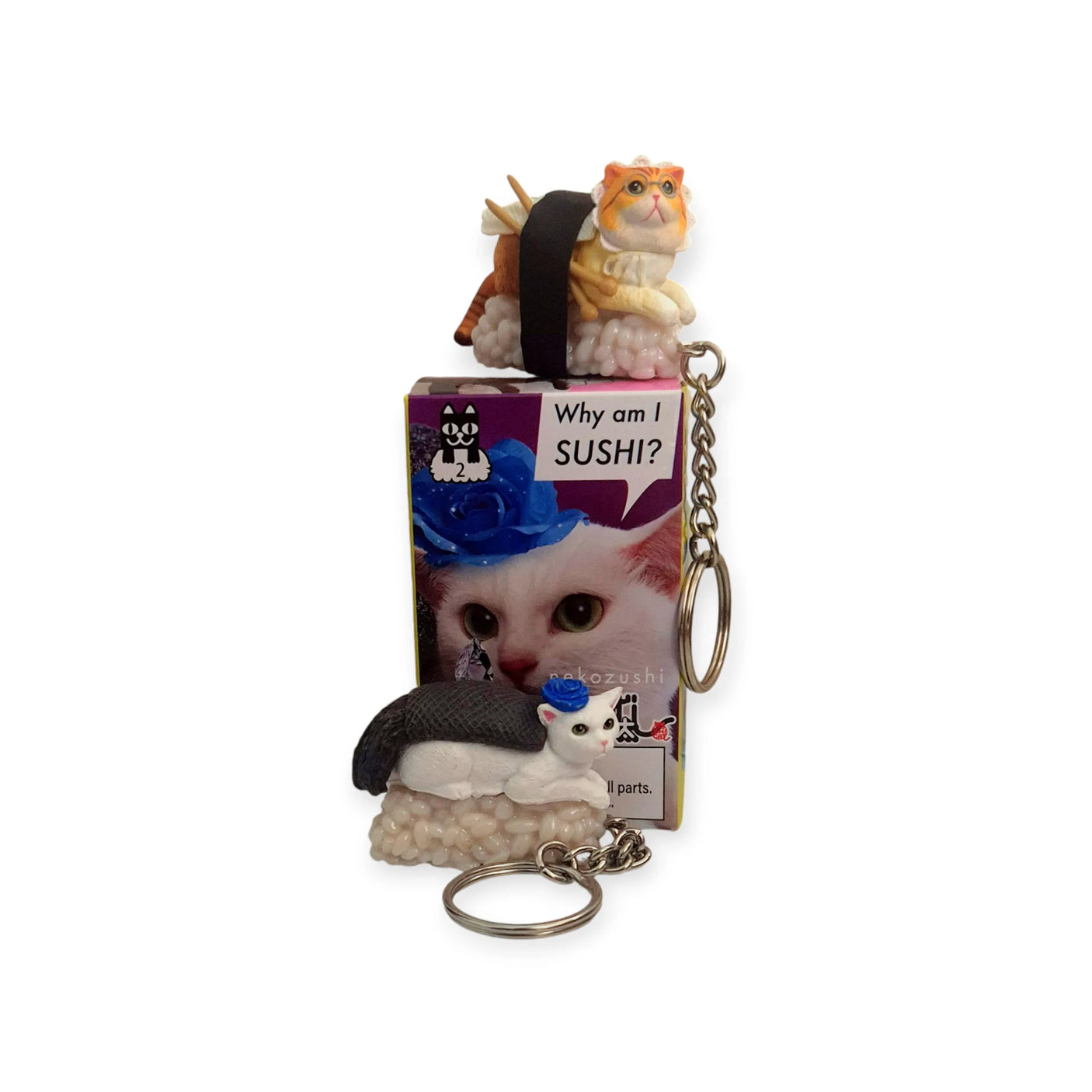 Experience the joy of Mofusand's Sushi Cat Keychain Blind Box - Vol.2, which features whimsical cat sushi figurines. One enchanting kitty, adorned with glasses, lounges on a box labeled "Why am I SUSHI?" and displays an adorable cat picture.