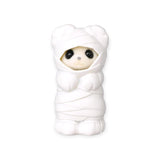White animal baby figurine in a hooded chef-style outfit