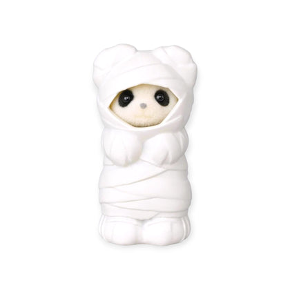 White animal baby figurine in a hooded chef-style outfit
