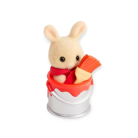 The Sylvanian Families Blind Bag - Baby Builder by Sylvanian Families features a cute bunny in a red scarf with a red paintbrush, sitting in a silver paint can—ideal for baby collectibles fans and whimsical displays.