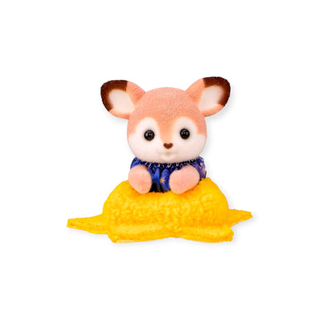 Orange fox figurine sitting on yellow blanket with navy outfit