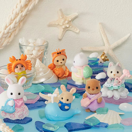 Sylvanian Families Blind Bag - Baby Seashore Friends Series by Sylvanian Families features adorable babies in colorful seaside outfits, displayed with sea shells, glass pieces, and starfish for a charming ocean-themed scene.