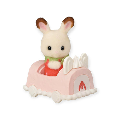 A delightful toy rabbit from the Sylvanian Families brand travels in a pink car with white details, featuring bunny ears on the front.