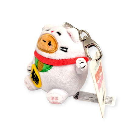 Introducing the Smoko Tayto Potato Lucky Cat Keychain Plushie by Smoko, a delightful plushie keychain featuring a whimsical cat design. It sports a charming brown snout, enhanced with a bright red collar and cheerful yellow bib. Complete with a sturdy metal clip and several tags, this accessory makes the perfect good luck charm to accompany you wherever you go.