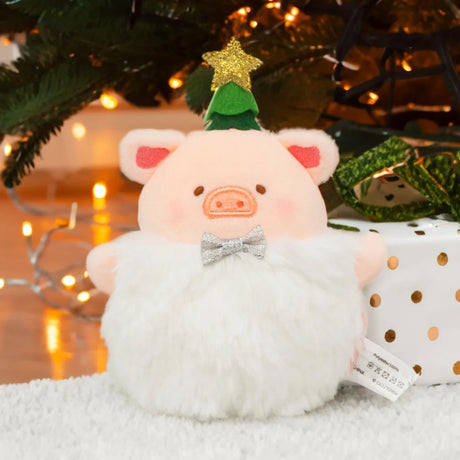 LuLu the Piggy - Snowball Lu Christmas Keychain by LuLu the Piggy features a festive pig plush with a silver bow tie and Christmas tree hat, displayed before a decorated tree and a white gift box with gold dots.