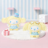 Yellow plush character with blue dress and embroidered face, sitting on soft rug