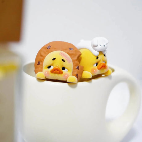 Duck toy figure lying down with a white small companion beside it