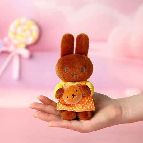 Brown bunny plush keychain holding a small bear, with orange checkered outfit