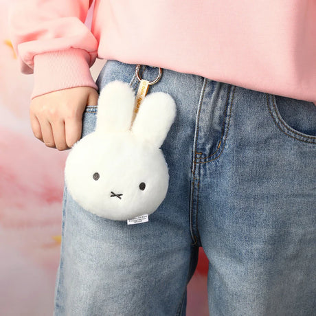 White plush bunny pouch keychain on blue jeans pocket with metal key ring
