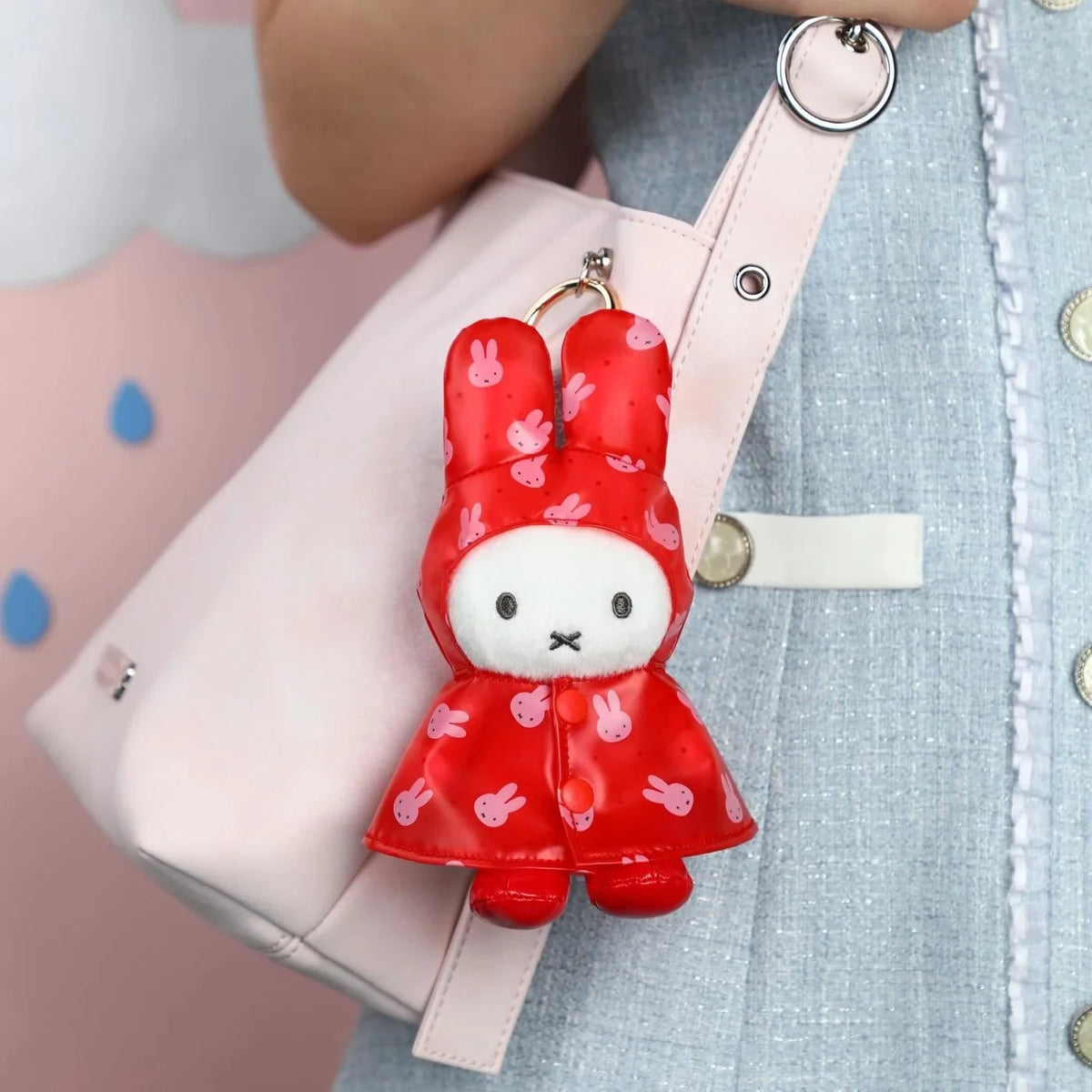 Red plush rabbit raincoat keychain with metal ring, hood, and white face panel