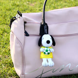 Snoopy soccer plush keychain hanging from a pale pink bag, holding a green ball