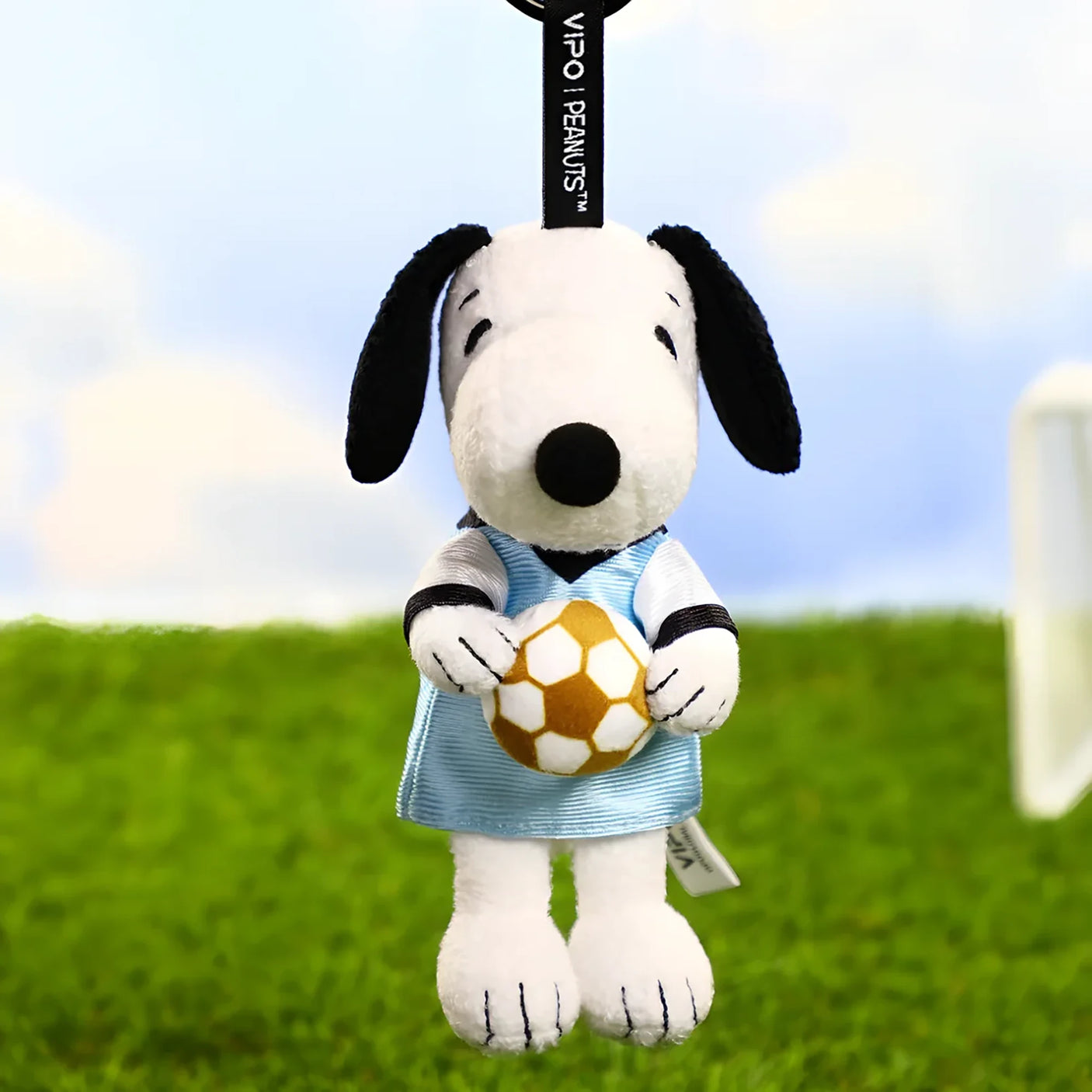 Snoopy soccer plush keychain holding a yellow soccer ball