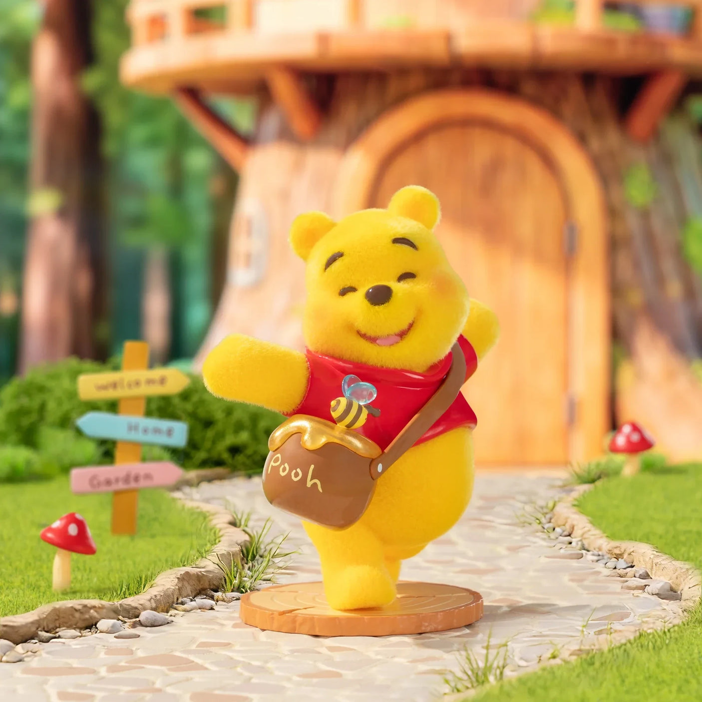 Winnie the Pooh figurine wearing a red scarf and holding a honey jar