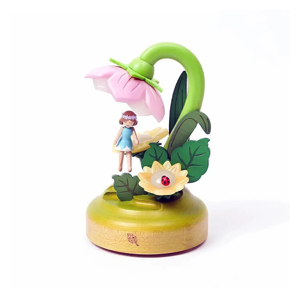 Introducing the Wooderful life - Fairy Night Light by Wooderful life: This enchanting decorative figurine serves as a wooden fairy night light, showcasing a girl beneath a large pink flower adorned with green stems and leaves. The design is beautifully completed by a smaller yellow flower accented with a red ladybug, all set on an eco-friendly rounded wooden base.