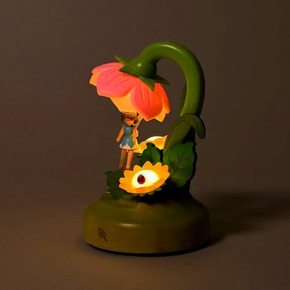 Explore the eco-friendly Wooderful life - Fairy Night Light by Wooderful life. This charming wooden piece is shaped like a green plant and features a large pink flower emitting a gentle light. Accompanying the design is a small figure beneath it, with an additional smaller yellow bloom against a dark backdrop, creating a tranquil ambiance.