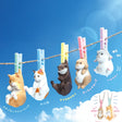 Yell's Washing Line Critters Charm Blind Box features five cute animal minifigure charms—cats, otter, rabbit, and hamster—dangling on a clothesline with colorful clothespins against a blue sky.