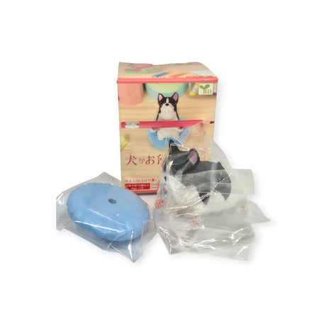 A Pen Holding Dogs Blind Box from the brand Yell features a collectible dog breeds figurine with accessories, neatly wrapped in plastic, displayed in front of its box.