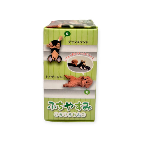 The box packaging, decorated with images of two plush dog toys from Yell's "Dog Resting on Edge Blind Box," is framed against a green striped background. Japanese text adds an element of surprise, hinting at the thrill of the blind box experience.