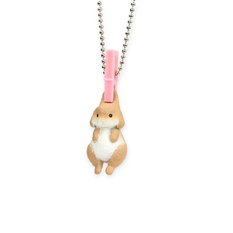 A small rabbit figurine from the Yell Washing Line Critters Charm Blind Box hangs by a pink clothespin on a silver ball chain necklace, displayed on a white background.